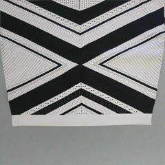 Black and white geometric patterned top on a tiled floor