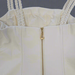 Close-up of a white dress with a gold zipper on a light gray background