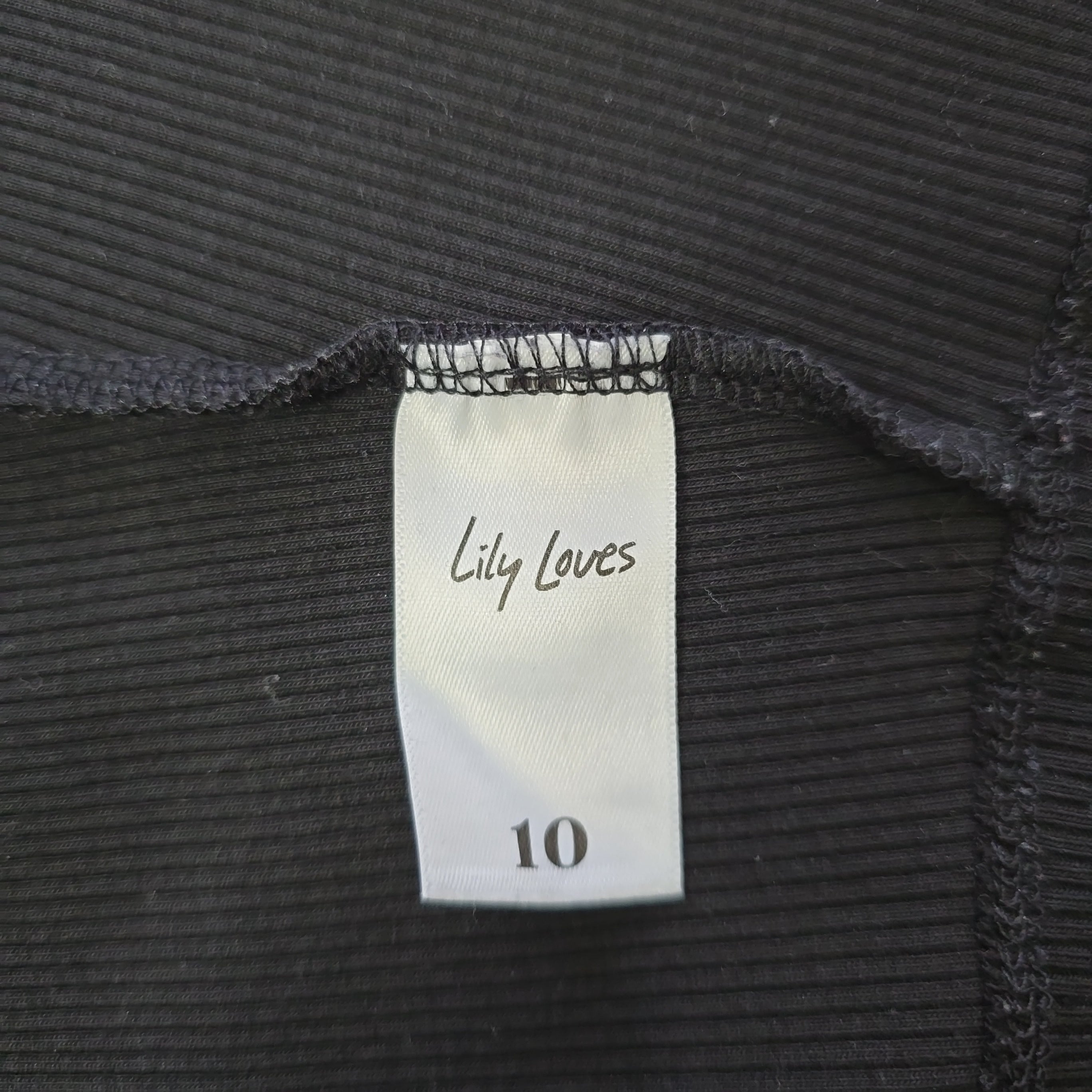 Label on black ribbed fabric with 'Lily Loves' branding