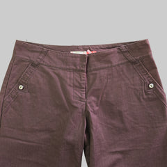 Folded maroon pants on a light gray surface