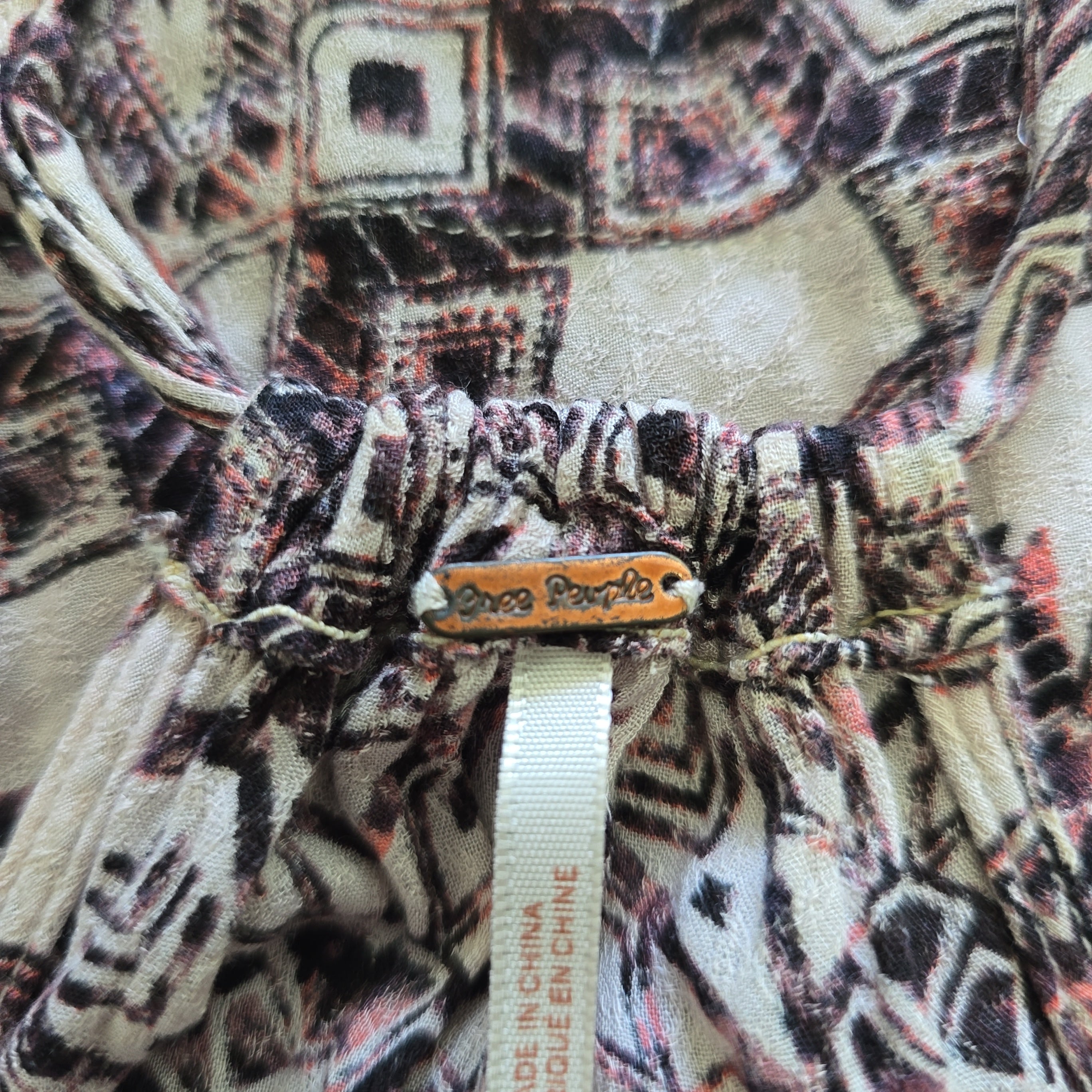 Close-up of a patterned fabric with a visible brand tag.
