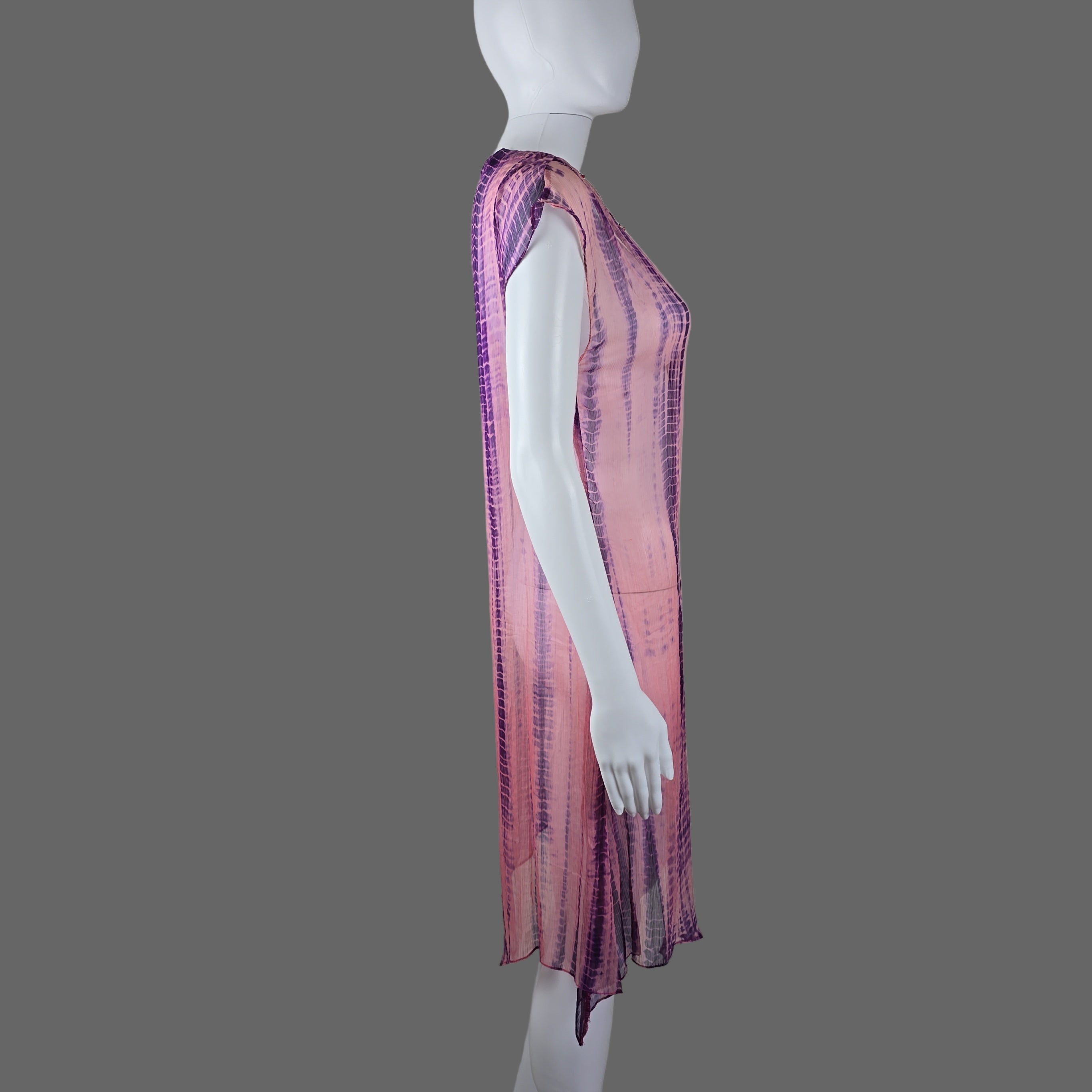 Mannequin draped with a pink and purple striped fabric against a plain background