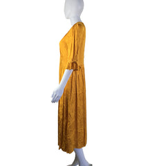 Yellow dress on a mannequin in front of a white background.