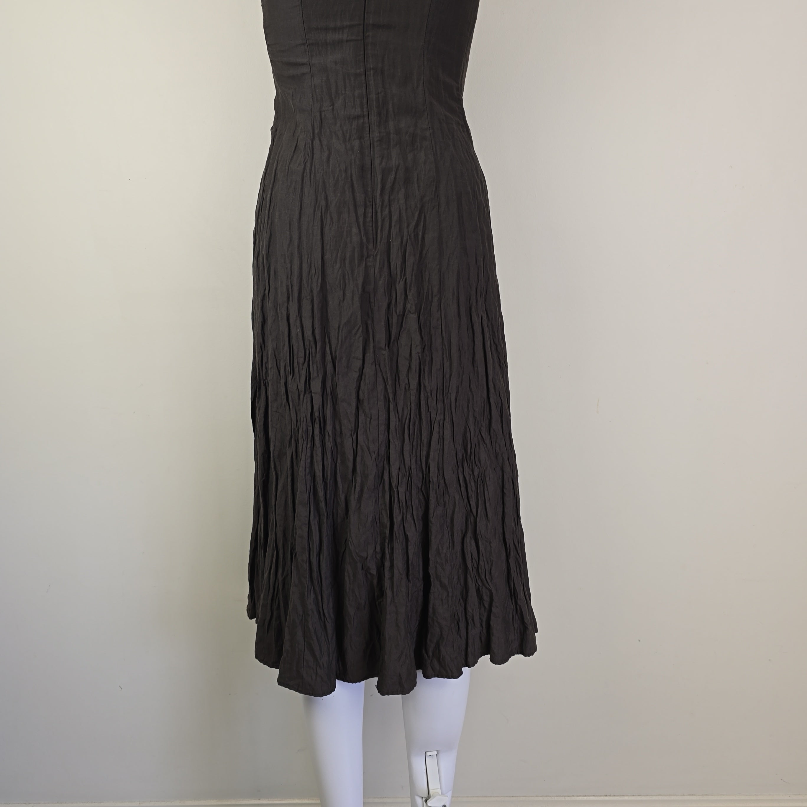 Black dress on a white surface with a neutral background