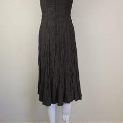 Black dress on a white surface with a neutral background