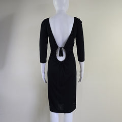 Black dress with a large bow on a mannequin against a plain background