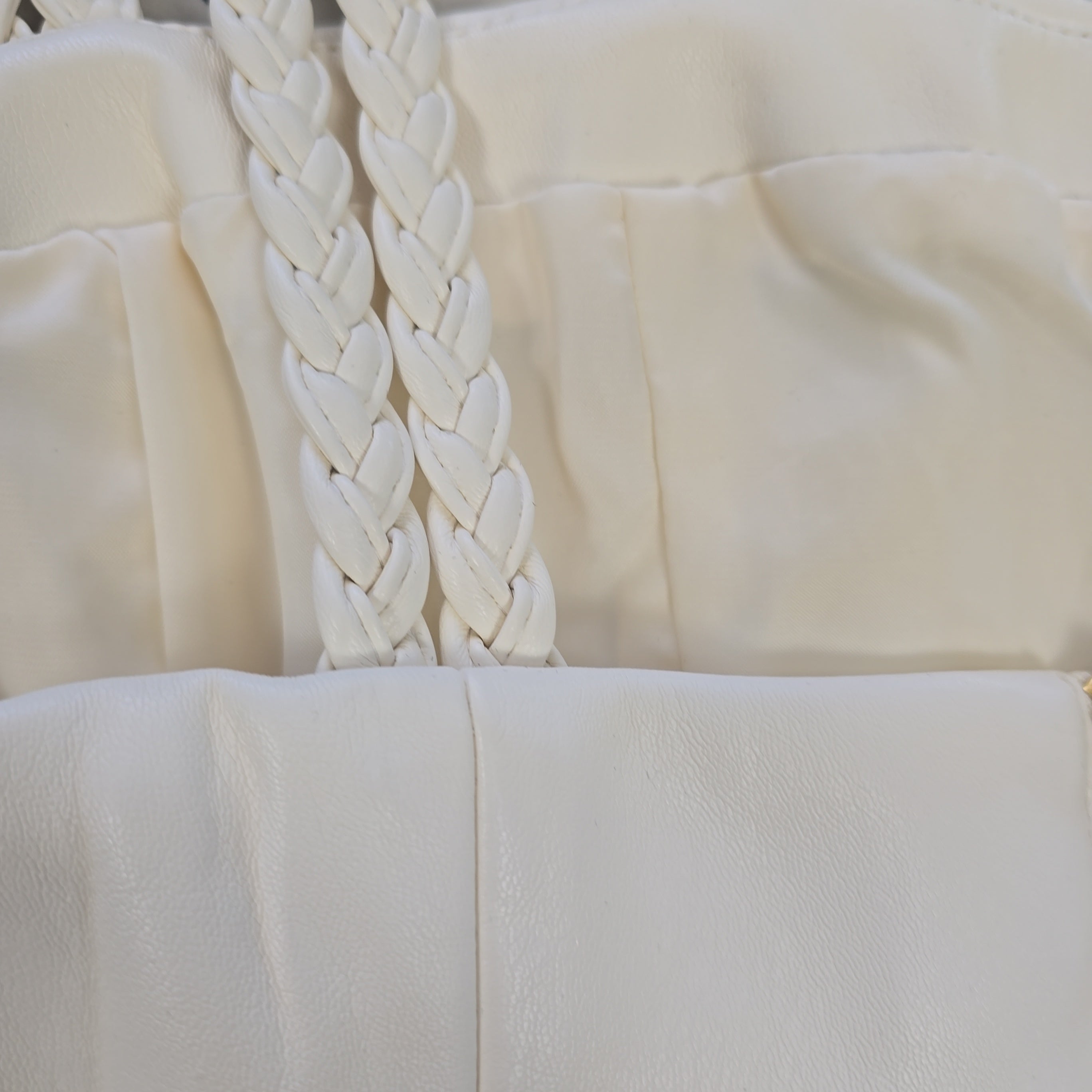 Close-up of a white textured fabric with braided detail