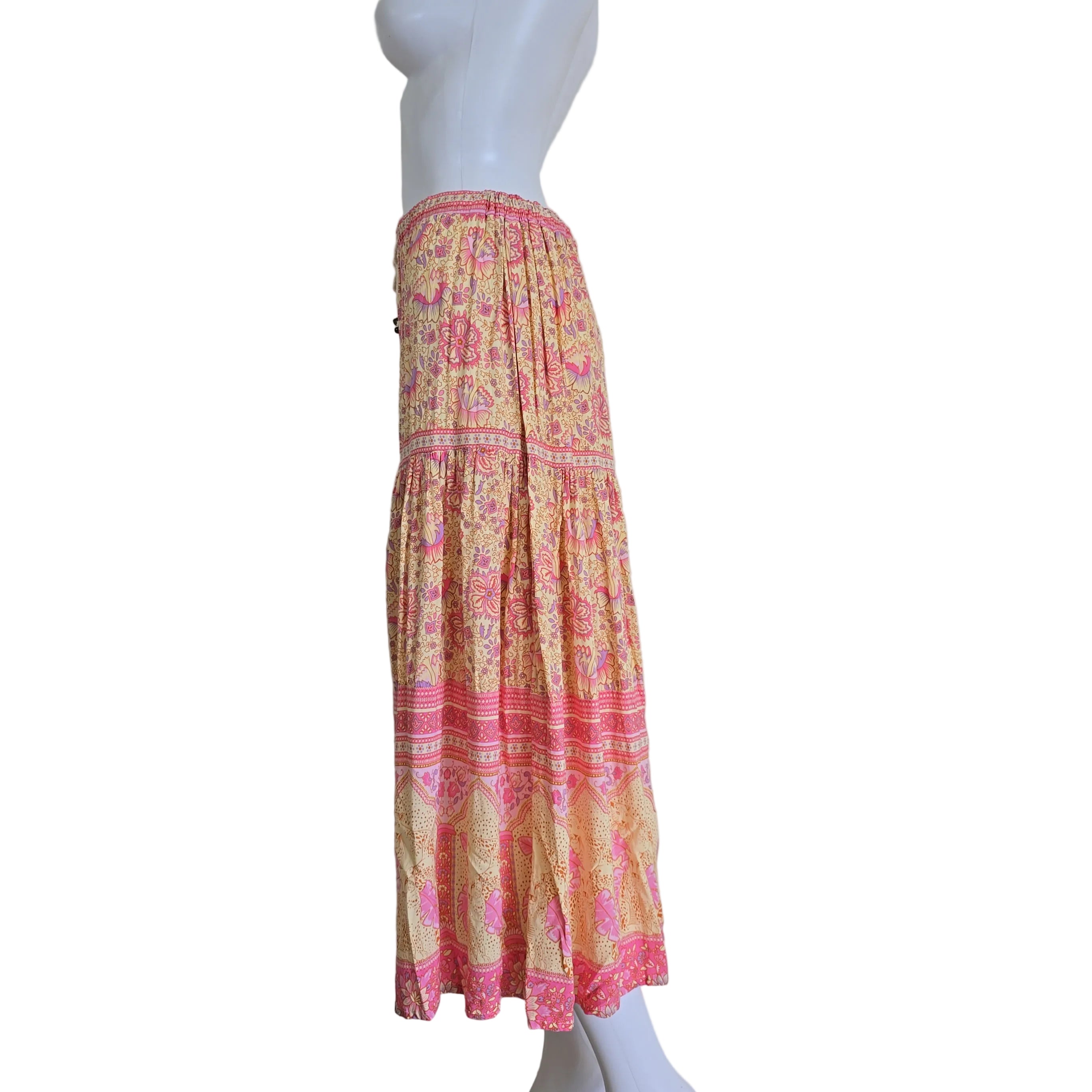 Mannequin with a pink and yellow patterned fabric on a plain background