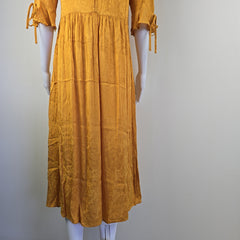Mustard yellow dress on a mannequin against a plain background