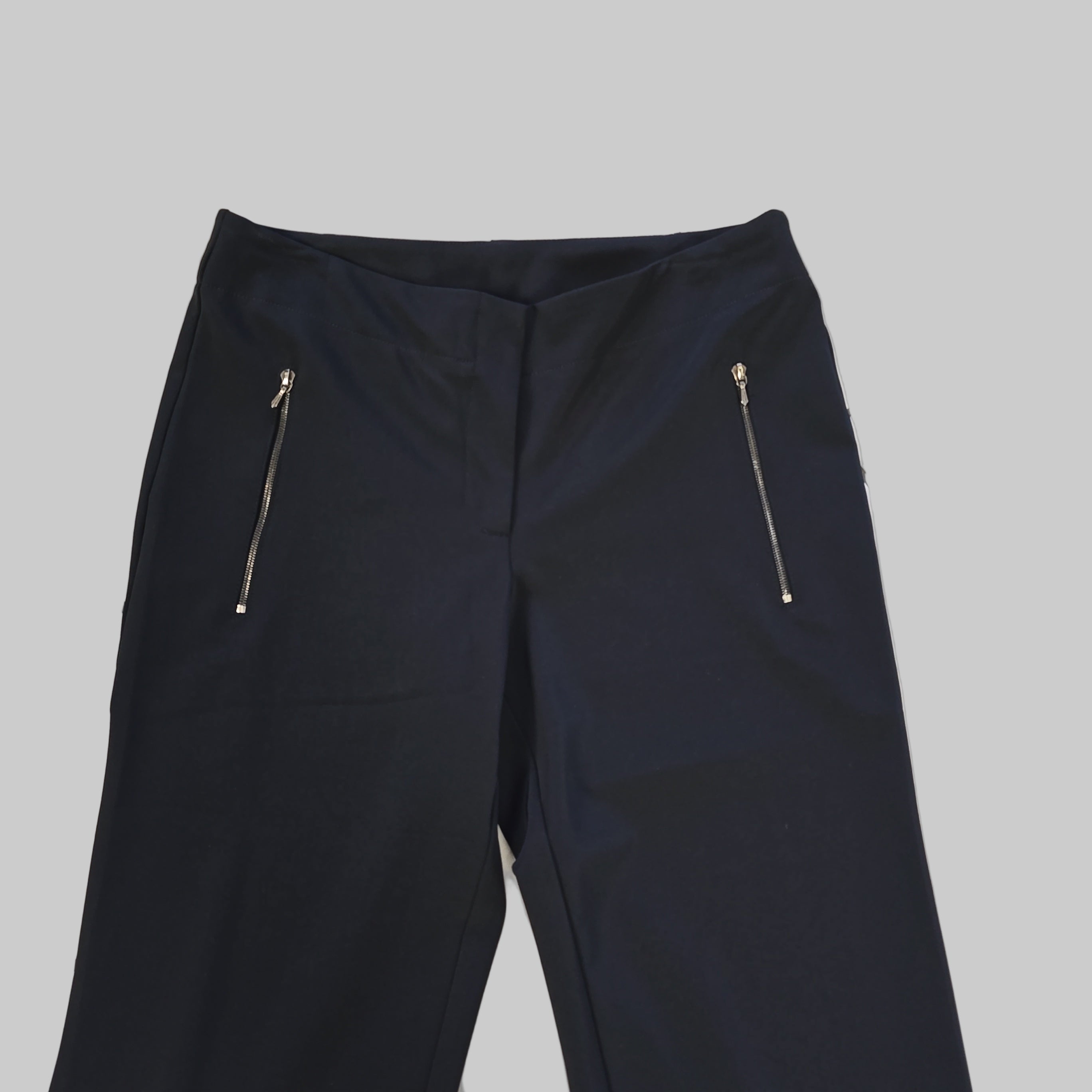 Black pants with zippers on a light tiled floor