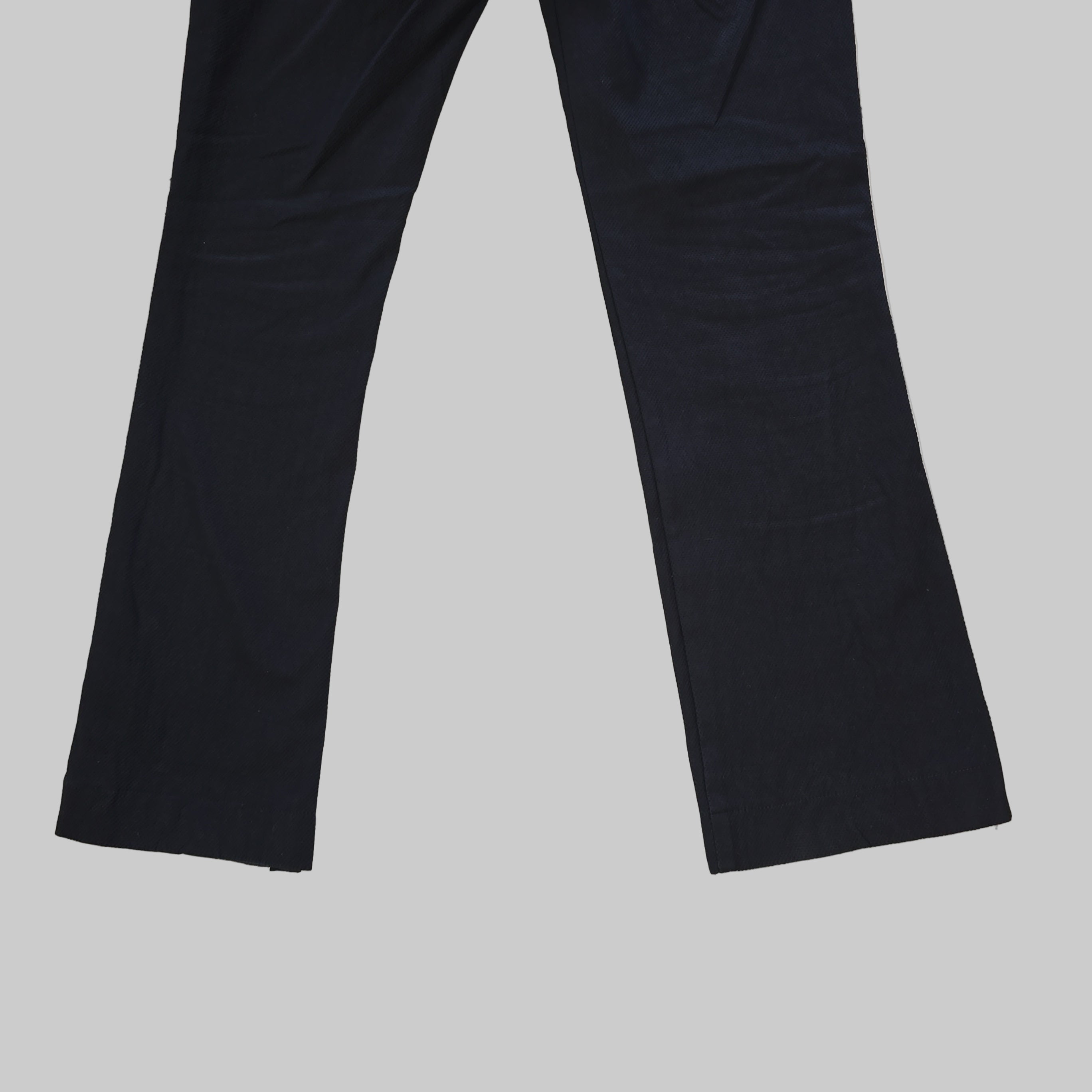 Two black pants legs on a tiled floor