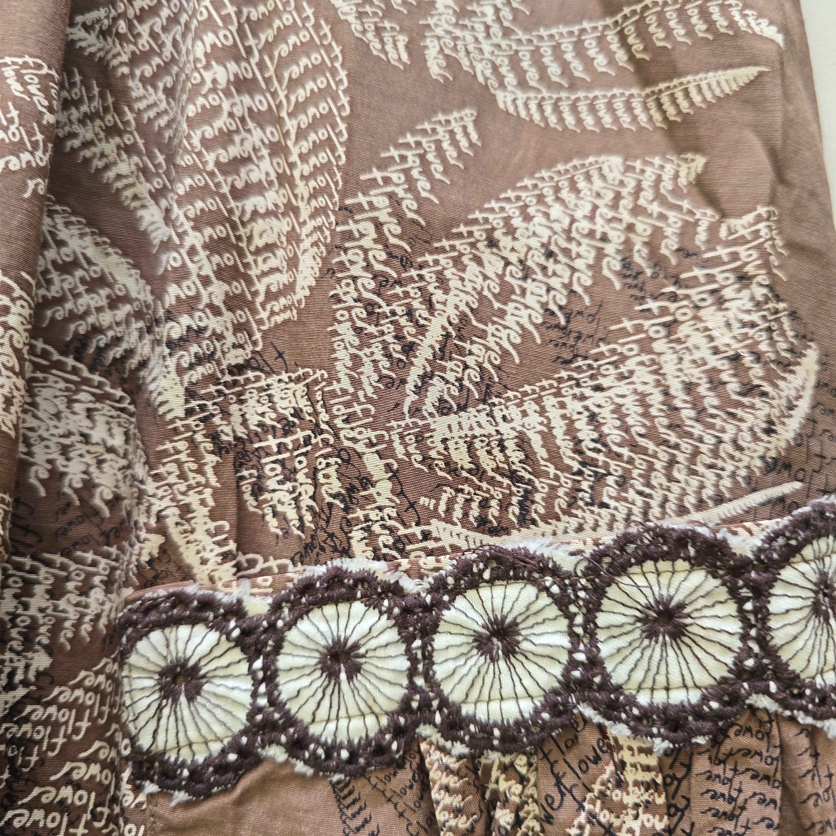 Textile with floral and circular patterns on a brown background