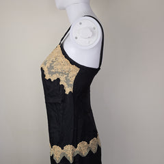 Black dress with beige lace details on a light background