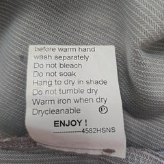Clothing label with care instructions on a textured fabric background