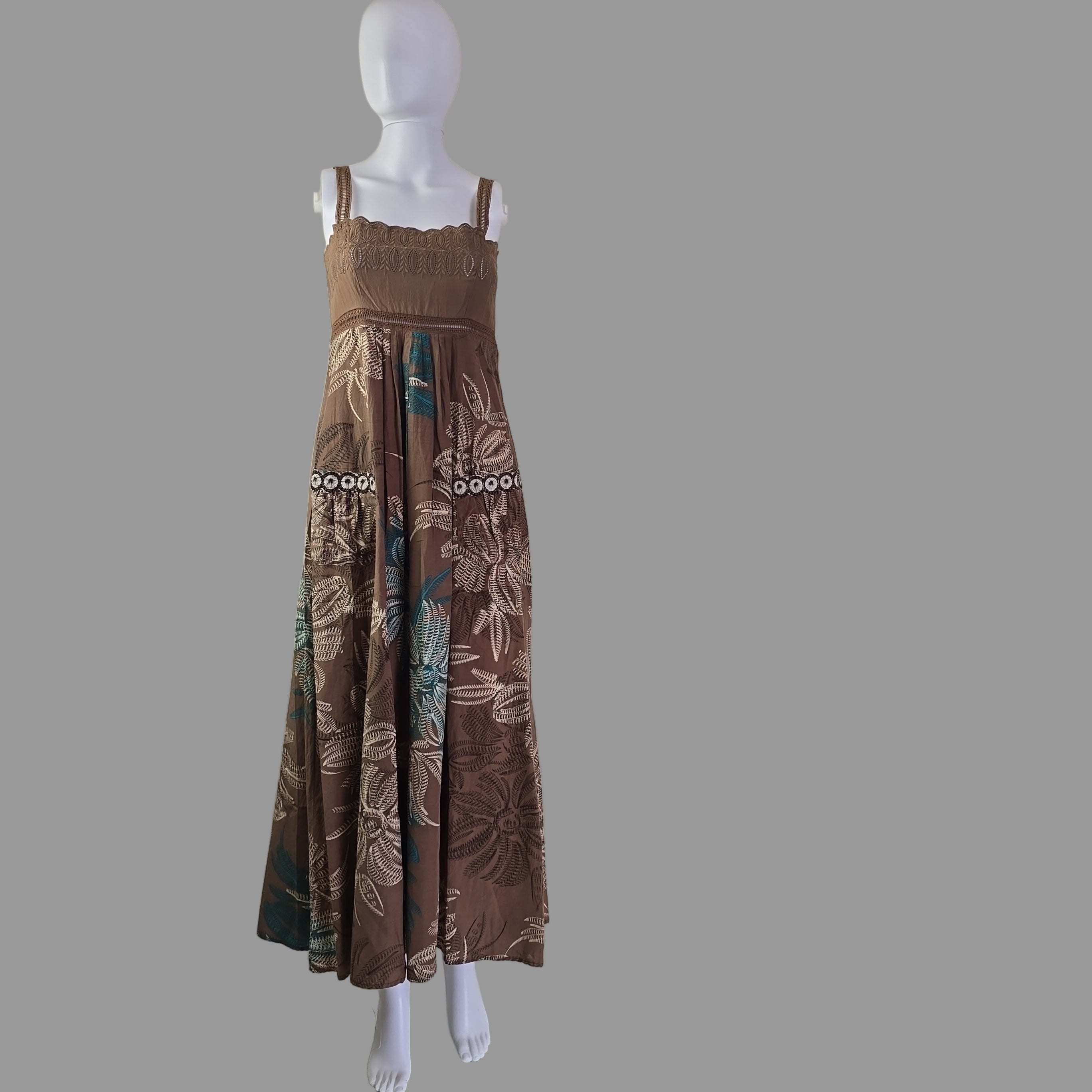 Brown floral dress on a mannequin against a white wall.