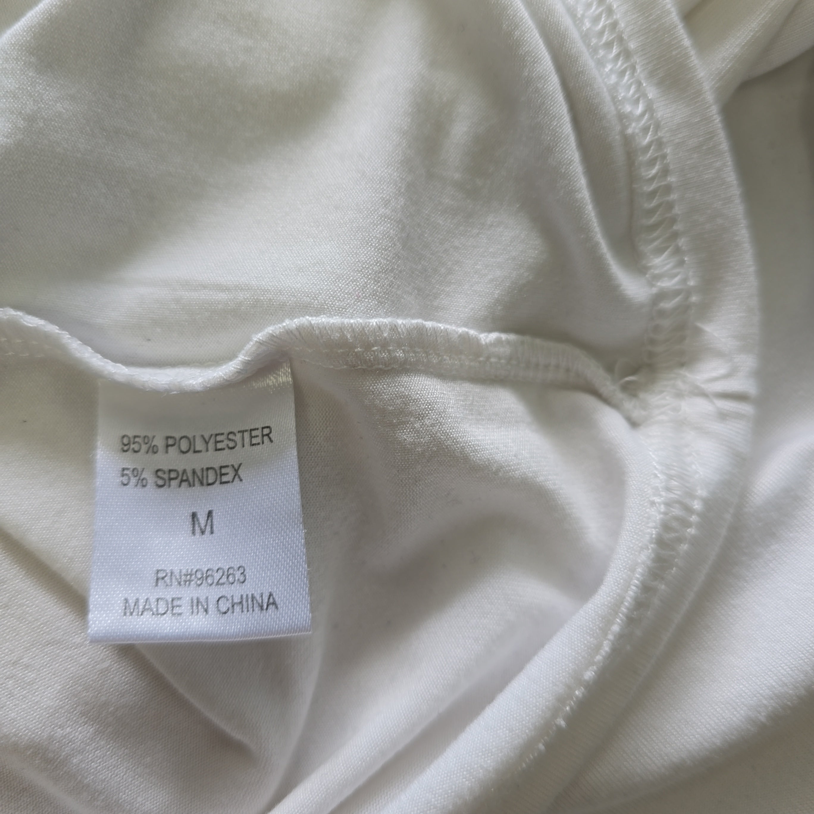 Close-up of a white fabric with a label on a beige background