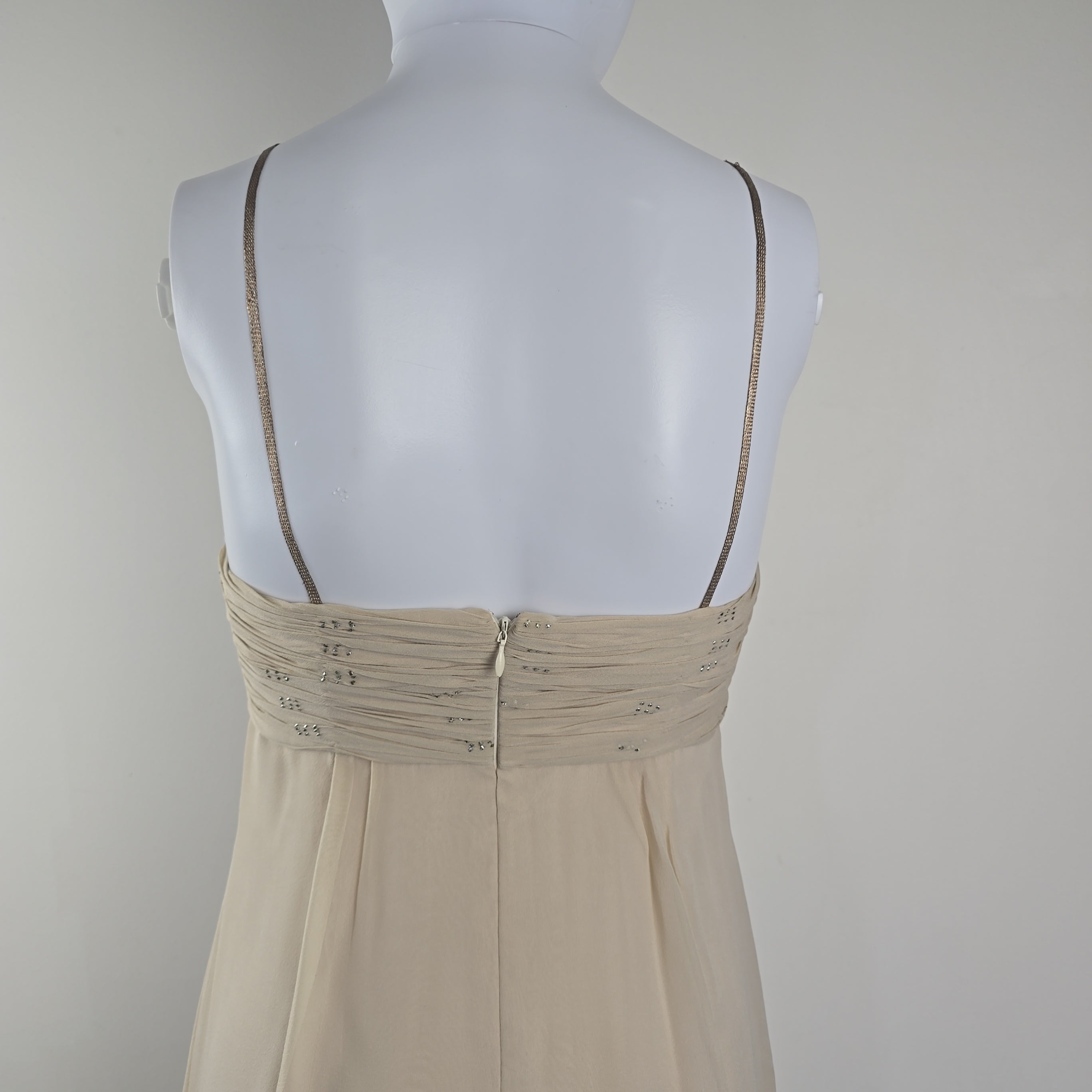 Mannequin wearing a beige dress on a plain background