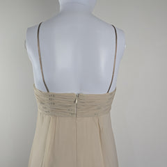 Mannequin wearing a beige dress on a plain background