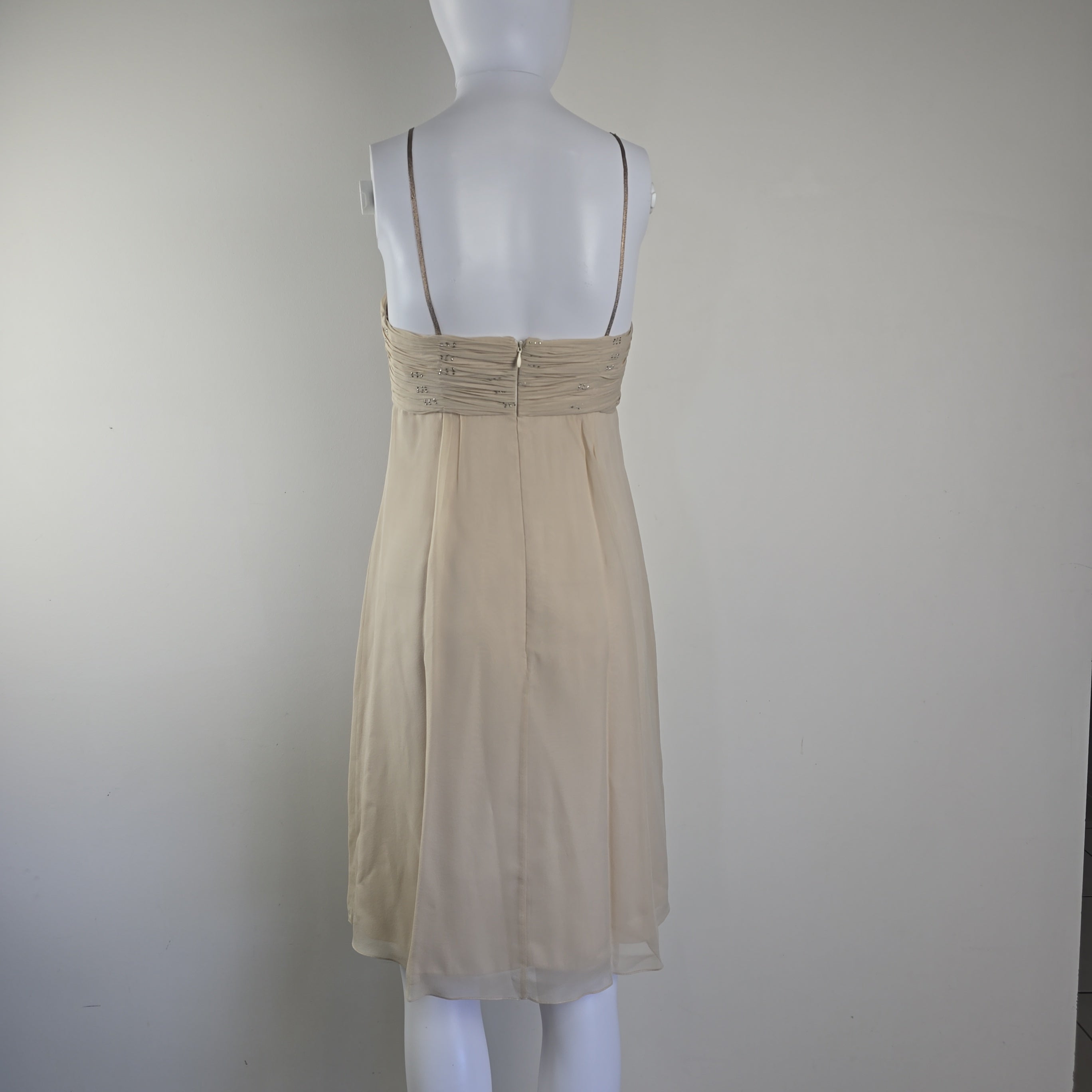Beige dress on a mannequin against a plain background