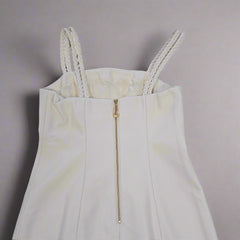 White dress with a gold zipper on a tiled floor