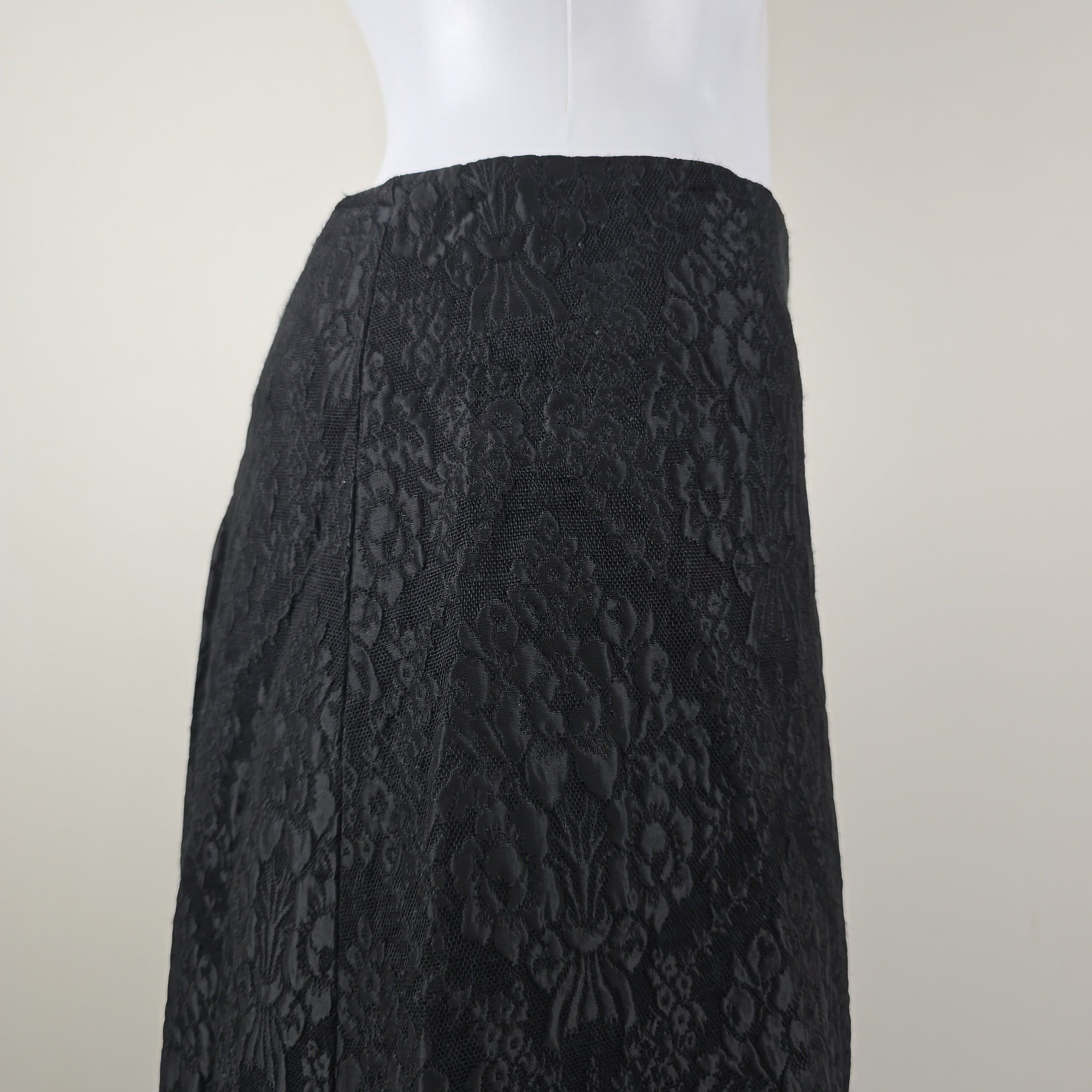 Black textured fabric skirt on a white background