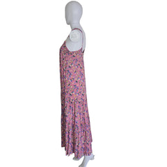Folded pink floral dress on a mannequin against a white wall.