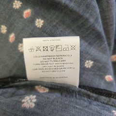 Clothing label on a floral-patterned fabric background