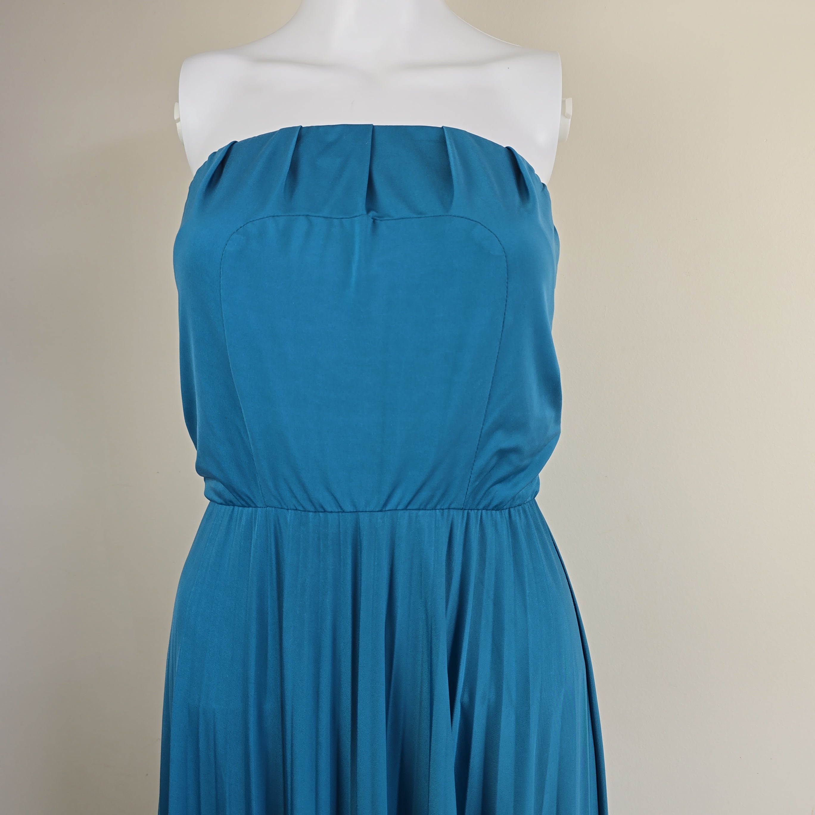 Blue strapless dress on a mannequin against a beige background