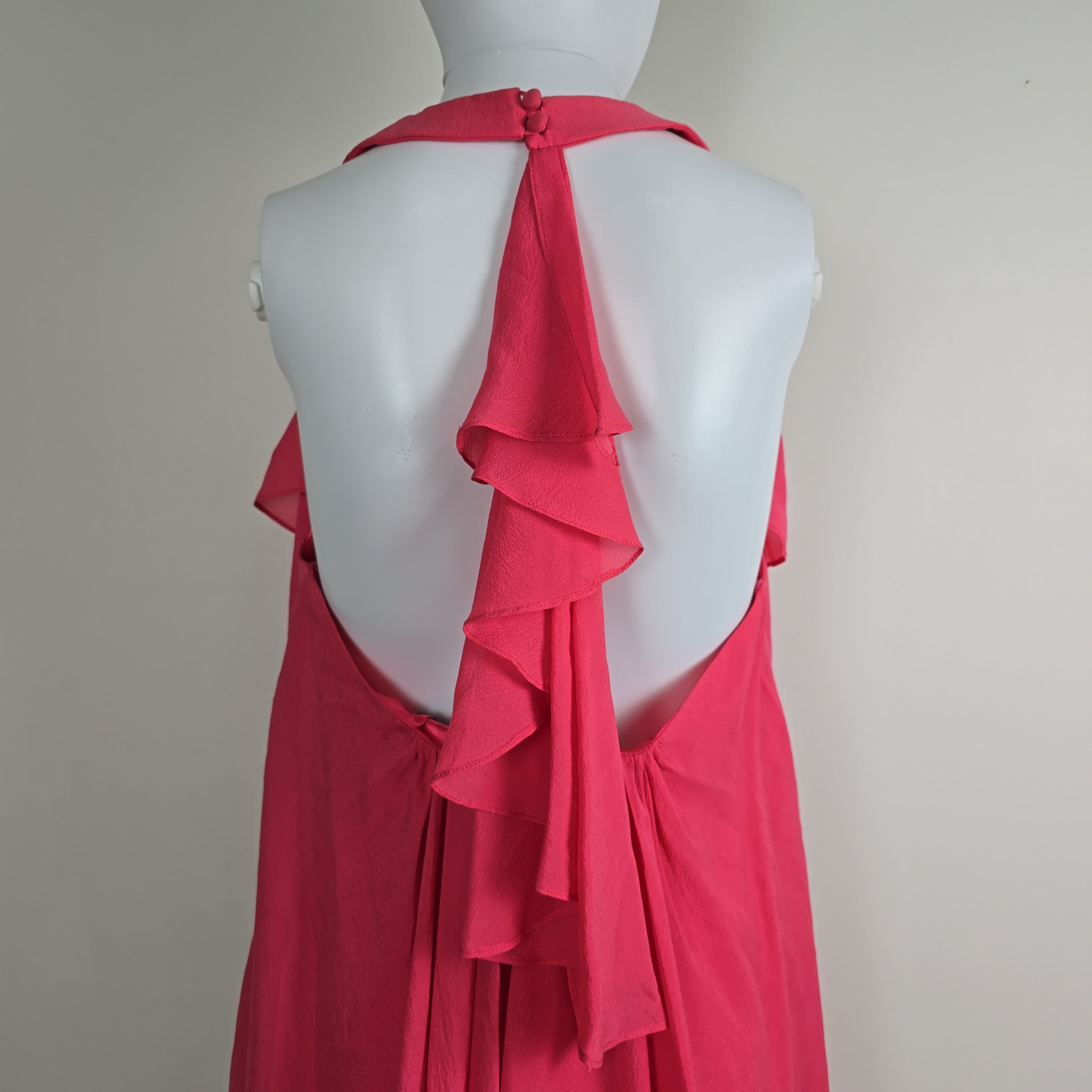 Red dress on a mannequin against a plain background
