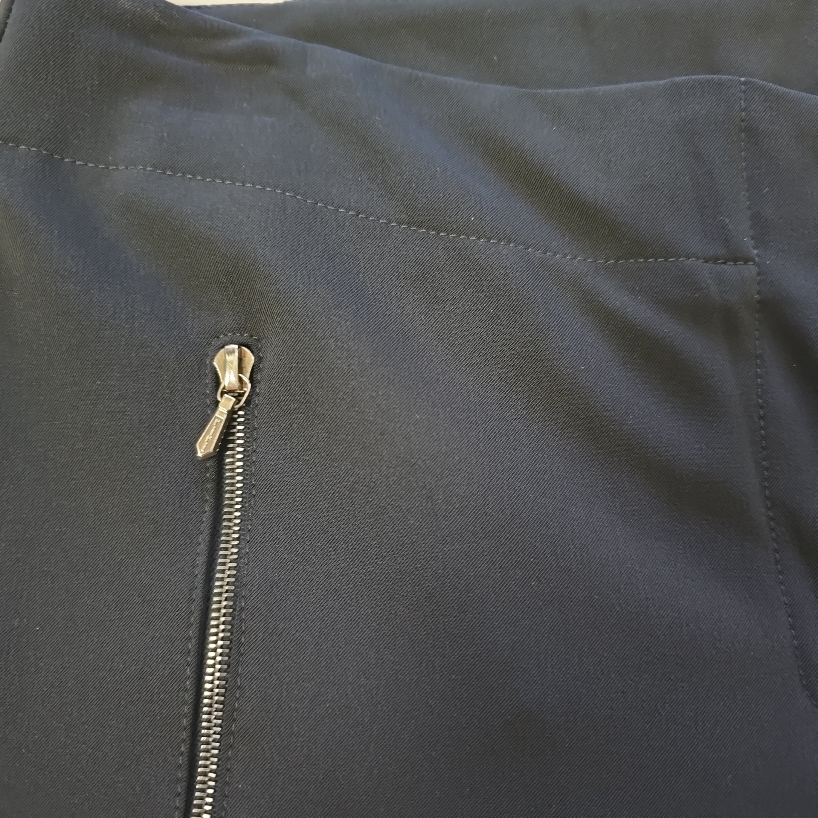 Close-up of a black pants with a gold zipper