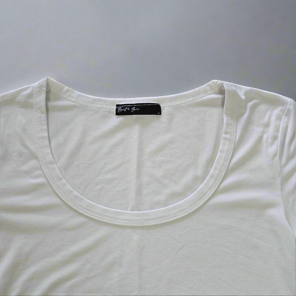 White tank top with a brand label on a tiled floor