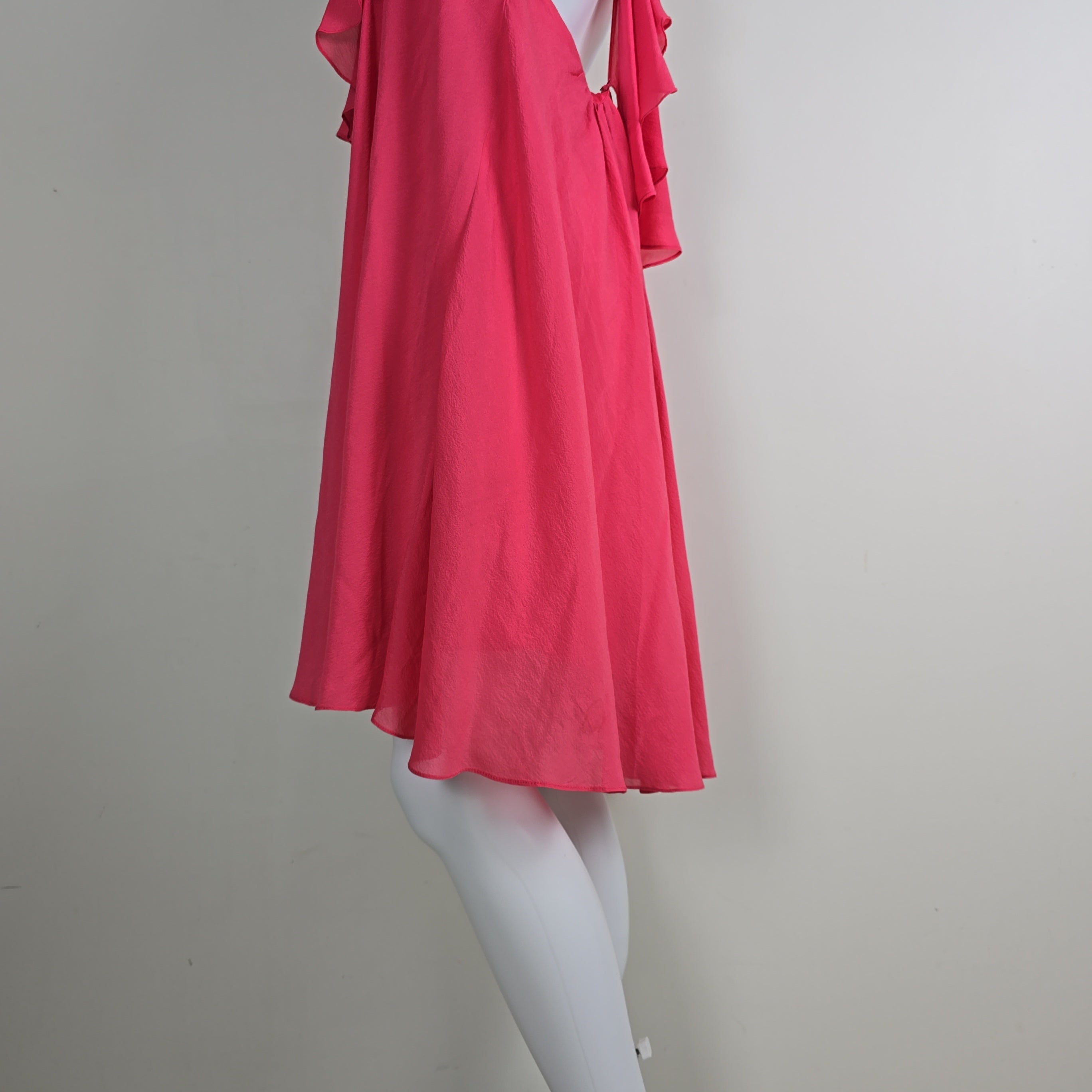 Mannequin wearing a bright pink dress against a plain background