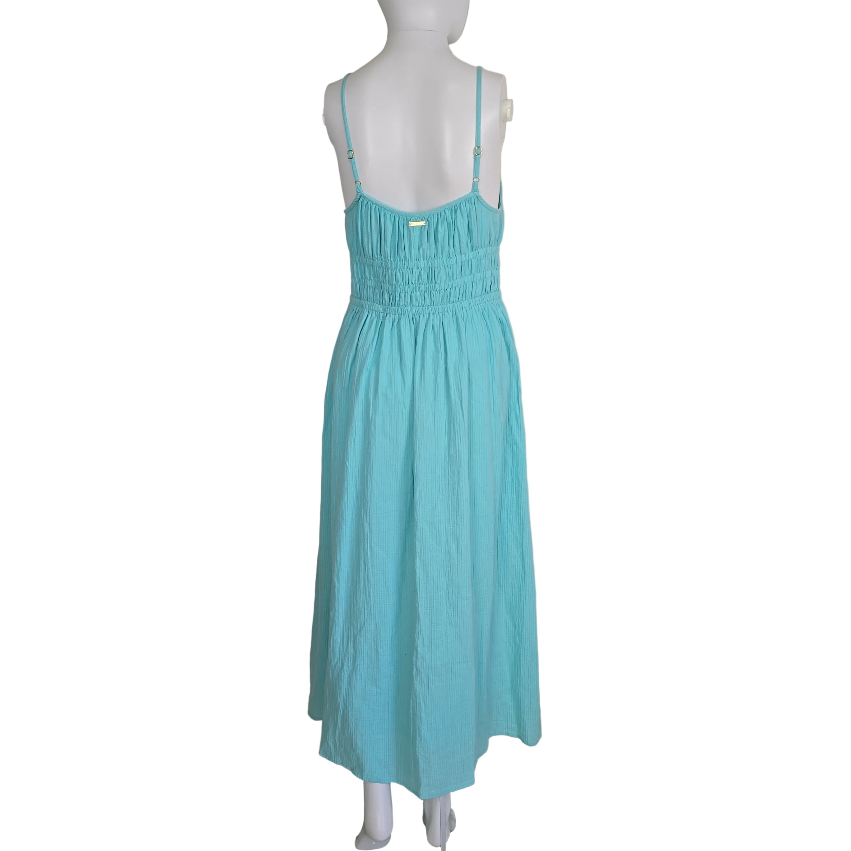 Turquoise dress on a mannequin against a white wall.