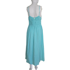 Turquoise dress on a mannequin against a white wall.