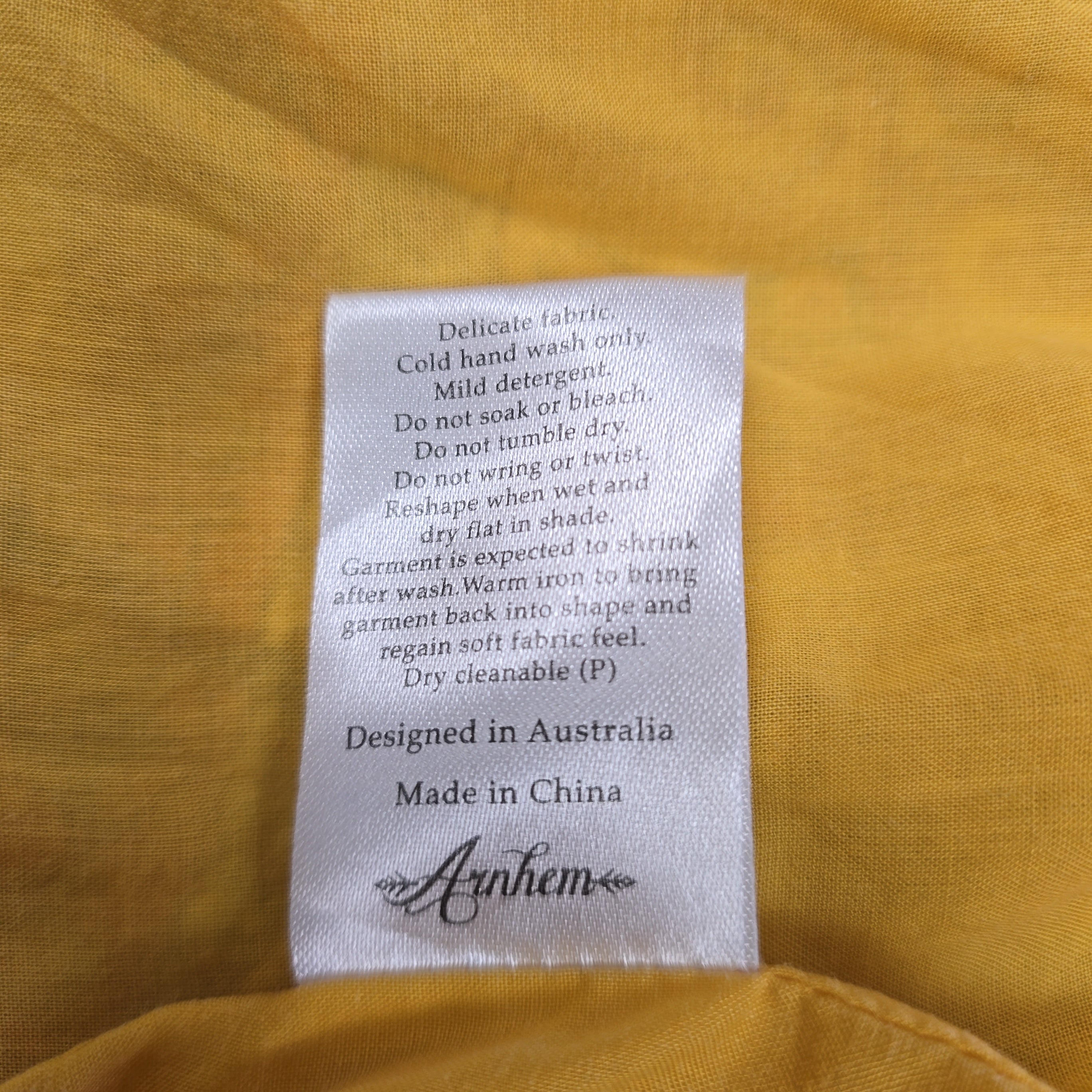 Clothing label on a yellow fabric background