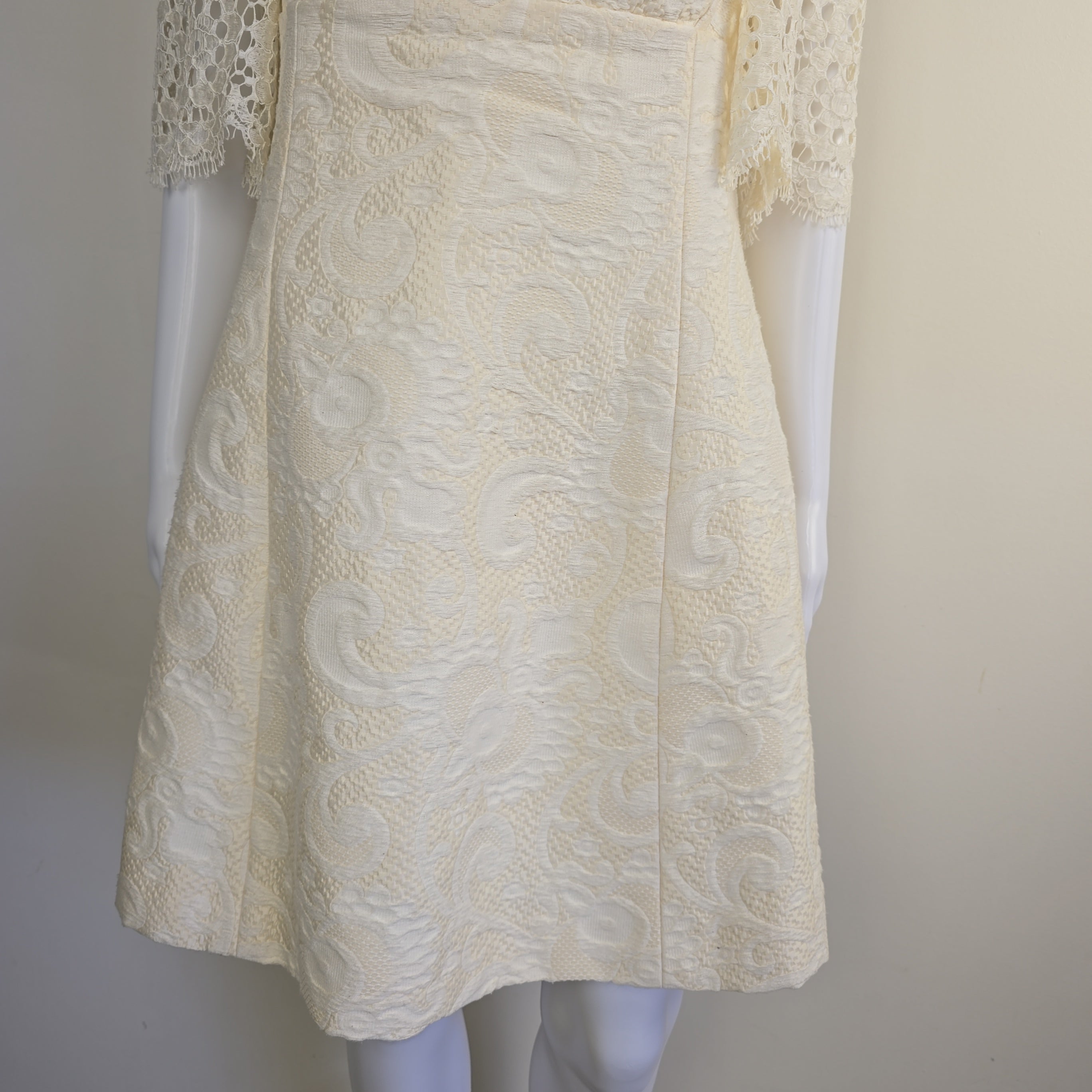 White textured fabric on a mannequin with a plain background
