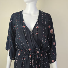 Black floral patterned top on a mannequin against a beige background