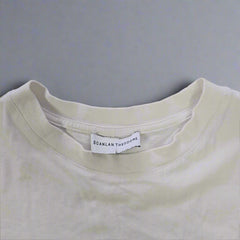 White t-shirt with a brand label on a tiled floor