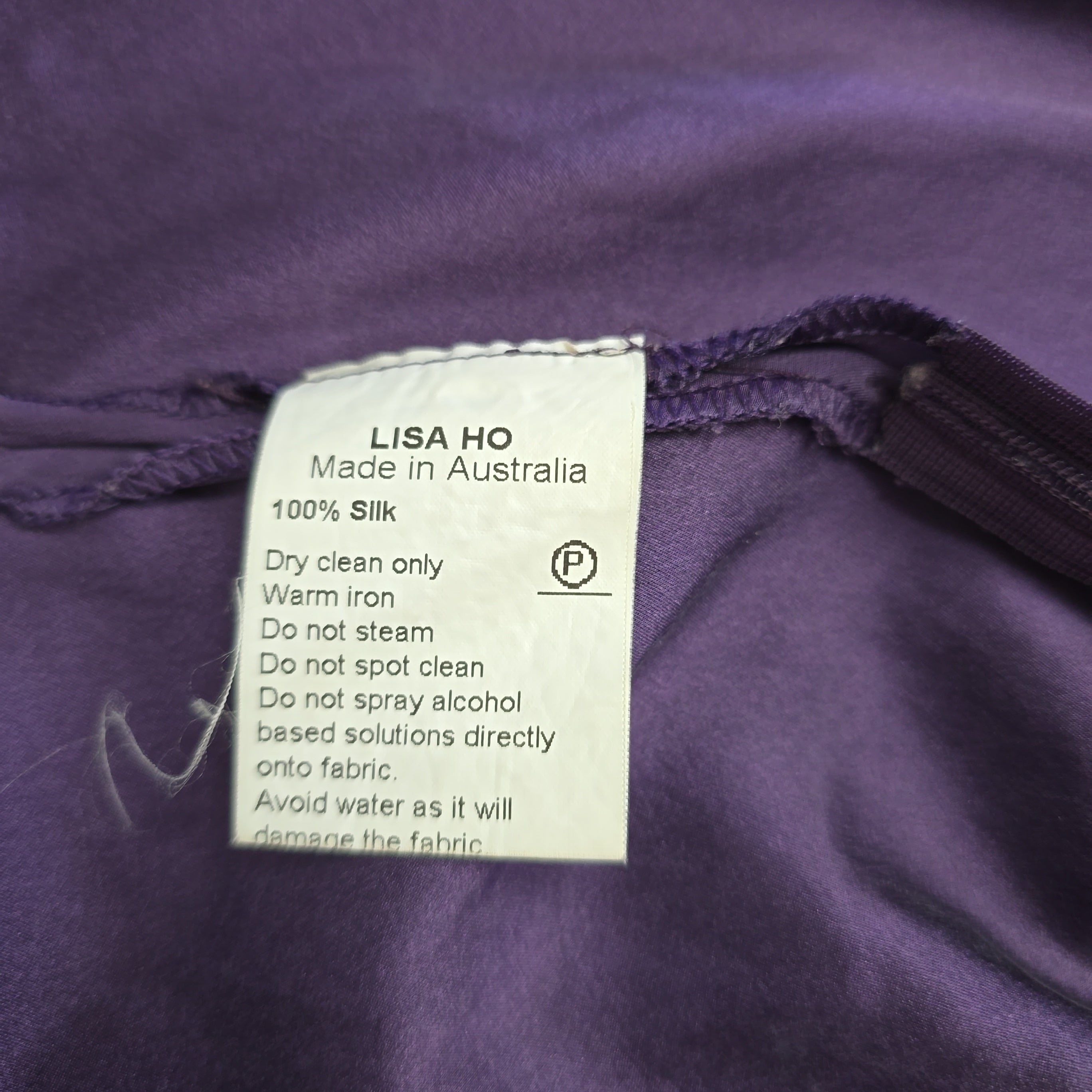 Label on a purple garment with text and symbols