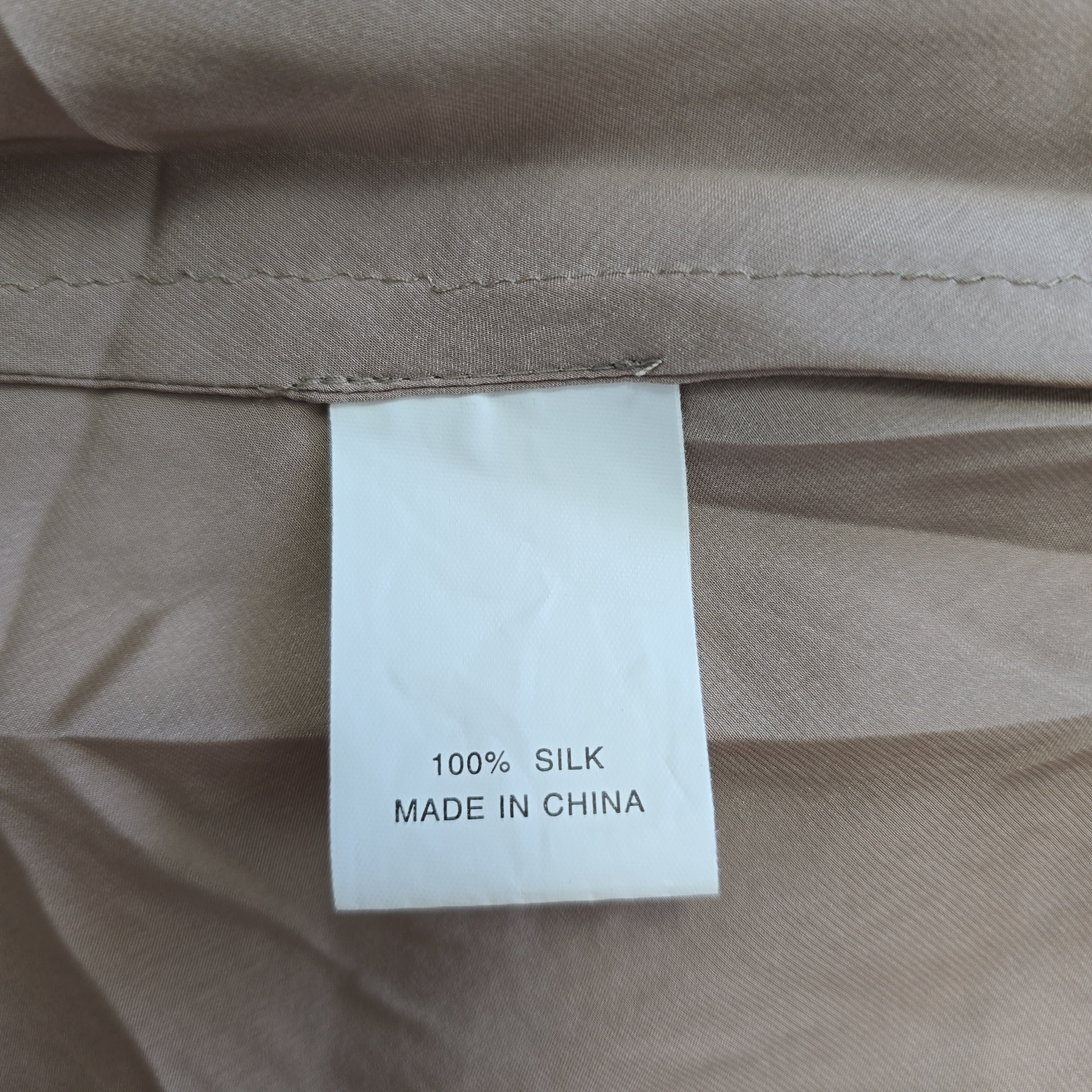 Label on beige fabric indicating 100% silk and made in China