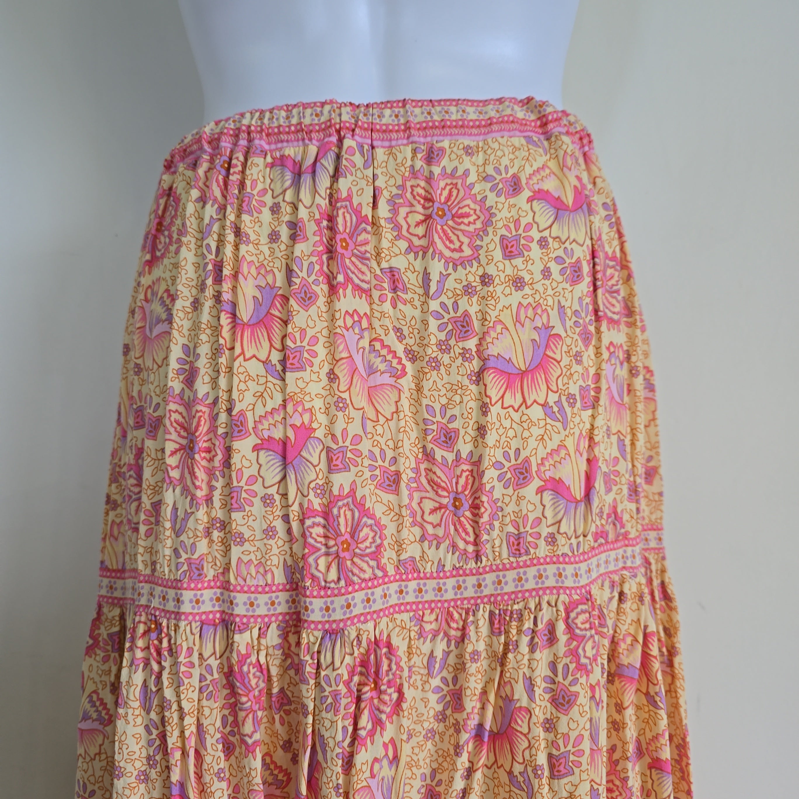 Mannequin wearing a floral skirt with pink and orange patterns on a white background
