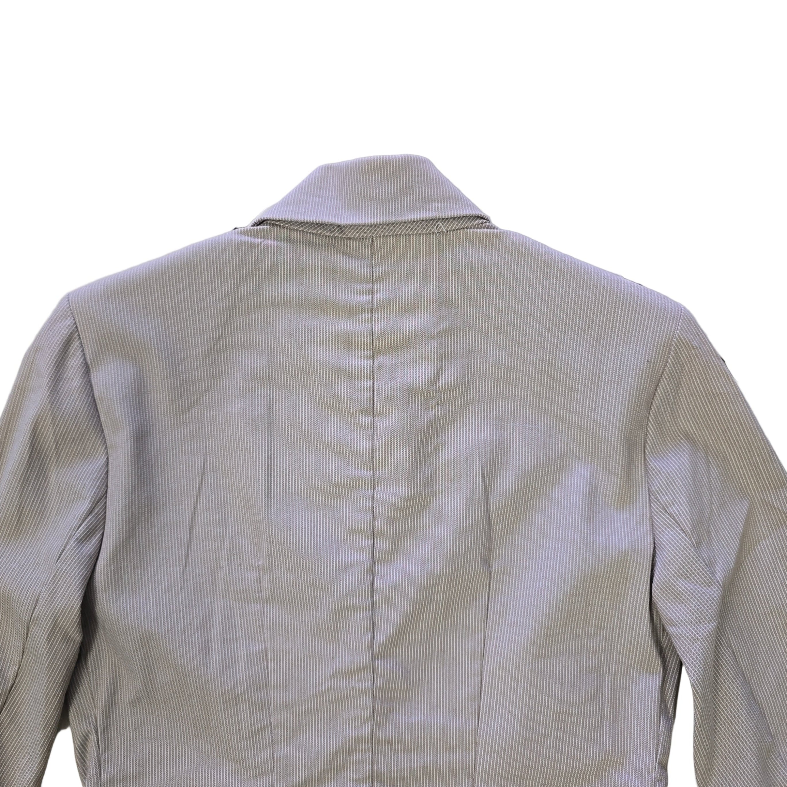 Light gray jacket on a white tiled floor