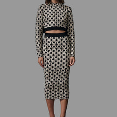 Woman wearing a black and white patterned outfit on a black background