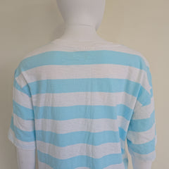 Mannequin wearing a blue and white striped garment against a plain background