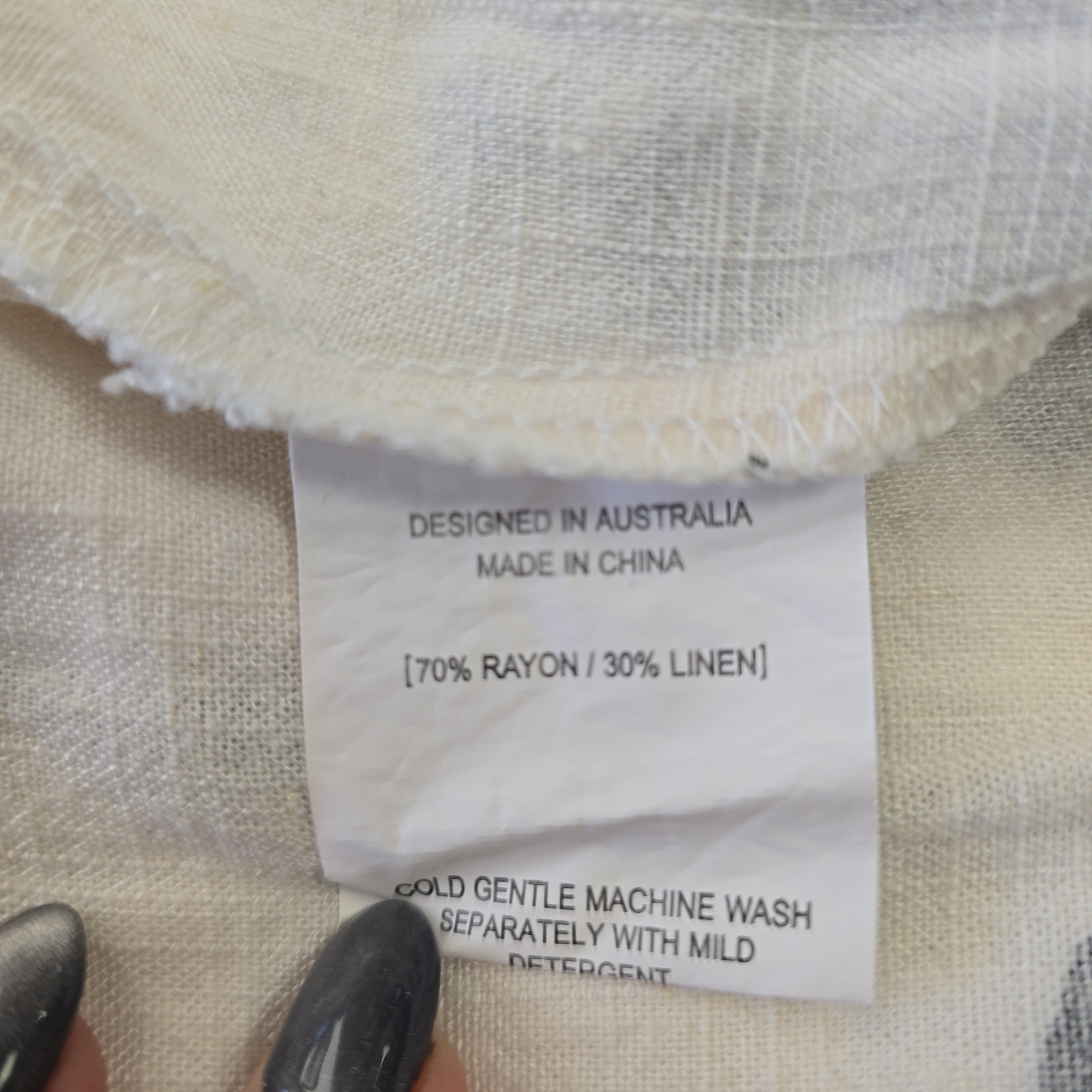 Fabric swatch with a label detailing design, manufacturing, and care instructions.