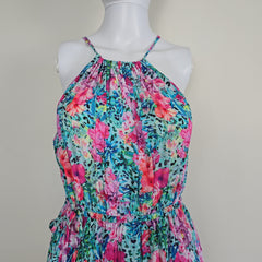 Multicolored floral dress on a mannequin against a plain background