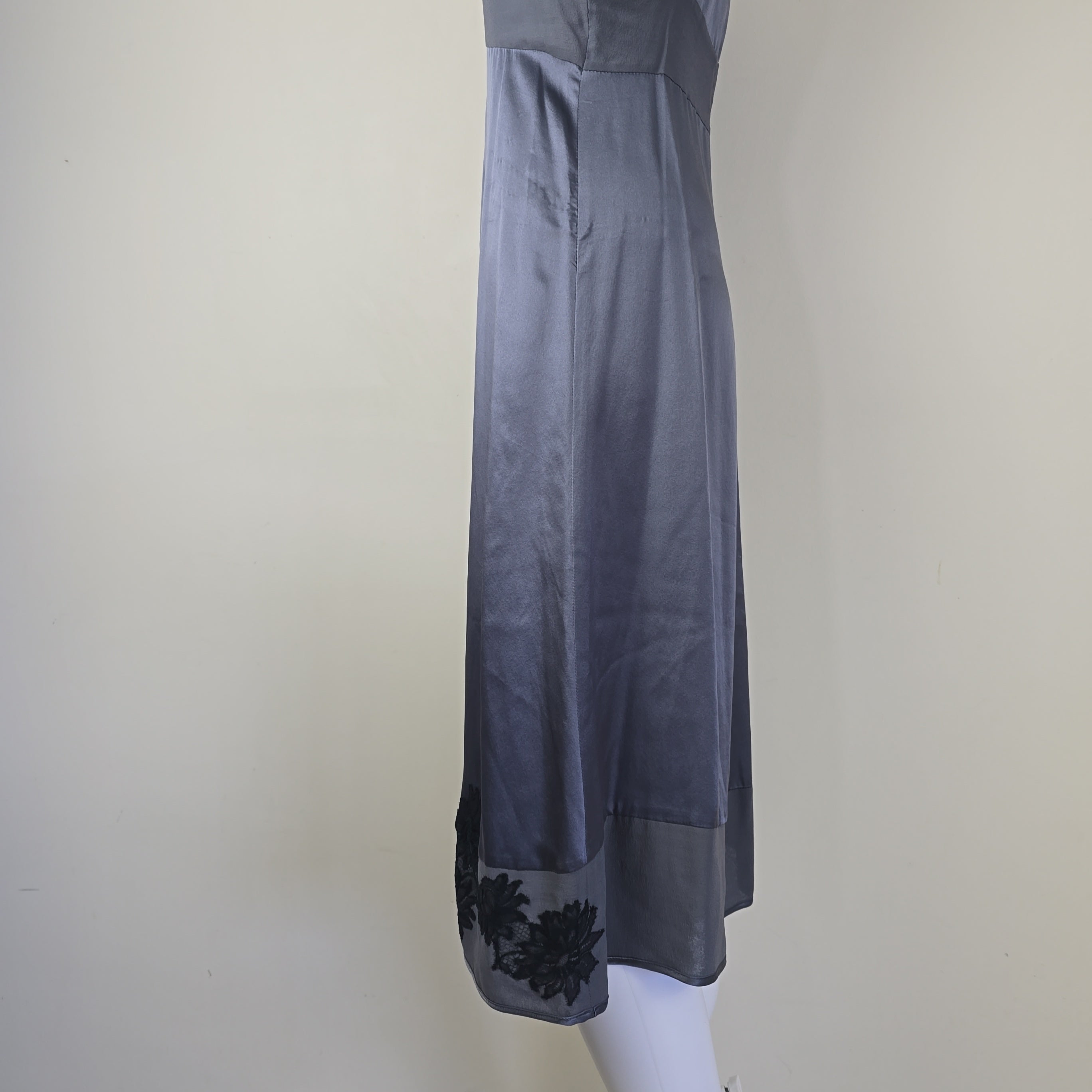 Dark gray dress with floral details on a mannequin against a plain background