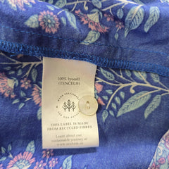 Fabric with floral pattern and a visible label on a blue background