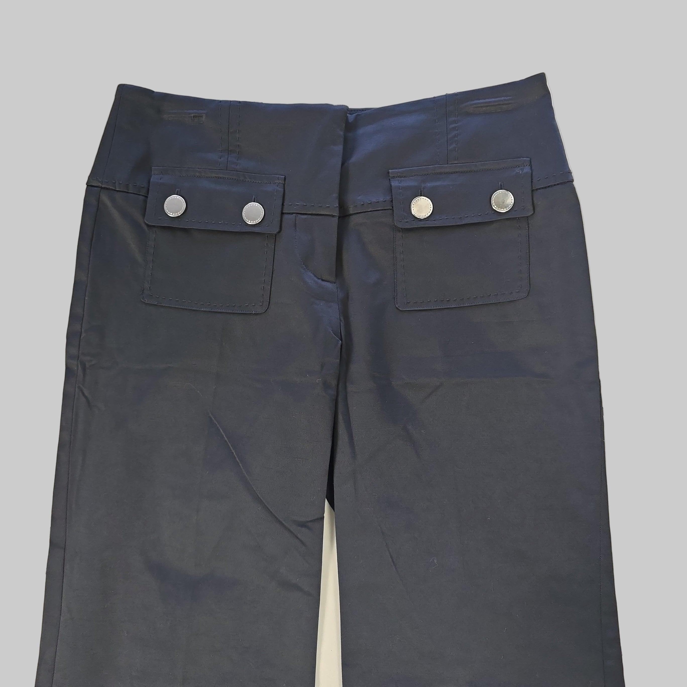 Black pants with button details on a tiled floor