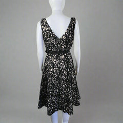 Black lace top on a mannequin against a plain background